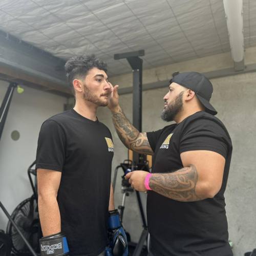 A coach talking a boxer through the plan before training